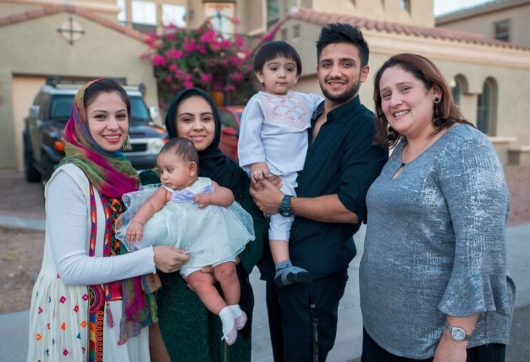 Family standing in front of house